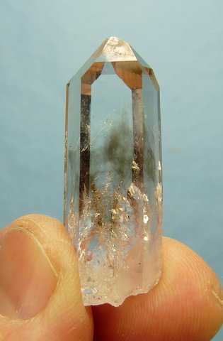 Clear quartz crystal with clouds of smoky colouring and gas inclusions