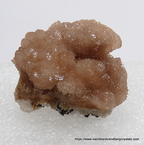 Olmiite aggregates on a calcite and feldspar matrix